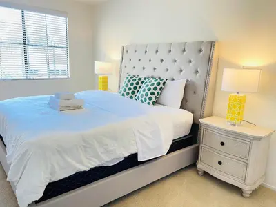 a bedroom with a large white bed and a night stand at Luxury Irvine 2Bedrooms 2Bathrooms kitchen Pool apartment in Irvine