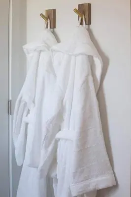 a group of white towels hanging on a wall at Coastal, Elegant, Modern, King Bed in San Diego