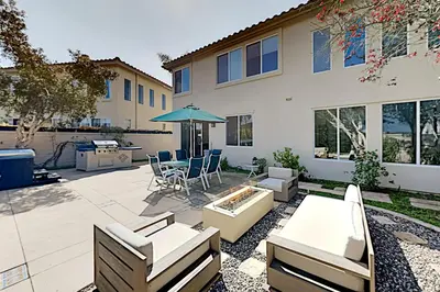 a patio with a table and chairs and an umbrella at Torrey Treats House in San Diego