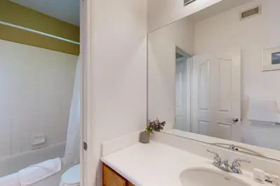 a white bathroom with a sink and a mirror at Torrey Treats House in San Diego