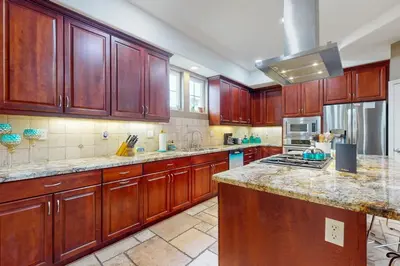 a large kitchen with wooden cabinets and a counter top at Westwood House in Oceanside