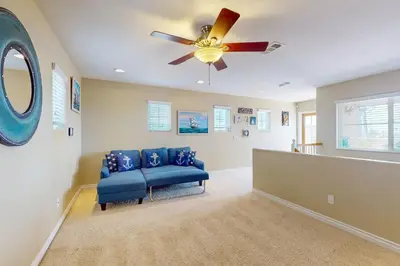 a living room with a blue couch and a ceiling fan at Westwood House in Oceanside