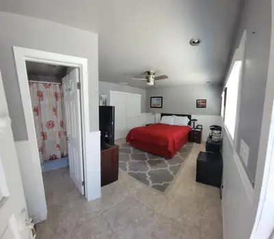 a bedroom with a bed with a red bedspread at Casa de Taft in La Mesa