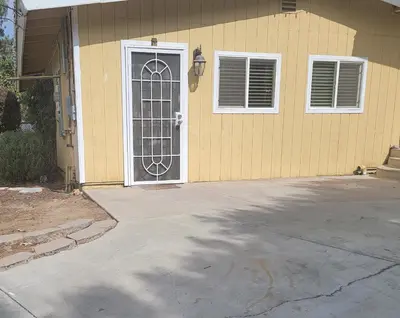 a yellow house with a door and a driveway at Casa de Taft in La Mesa