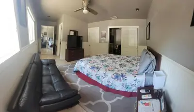 a bedroom with a bed and a leather couch at Casa de Taft in La Mesa