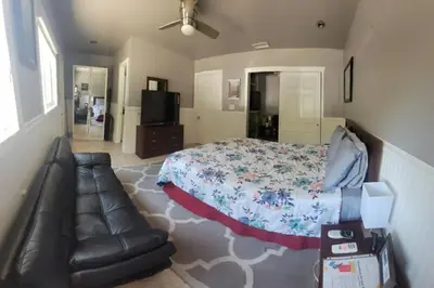 a bedroom with a bed and a leather couch at Casa de Taft in La Mesa