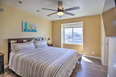 a bedroom with a bed and a ceiling fan at Stunning Oceanside Condo Walk to the Beach! in Oceanside