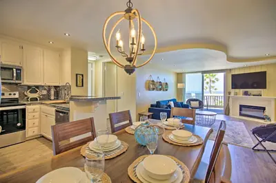 a dining room and kitchen with a table and chairs at Stunning Oceanside Condo Walk to the Beach! in Oceanside