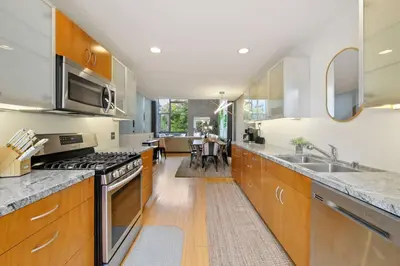 a kitchen with wooden cabinets and stainless steel appliances at New York Style Penthouse in the heart of the city in San Diego