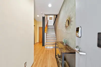a hallway with a staircase with a wooden table at New York Style Penthouse in the heart of the city in San Diego