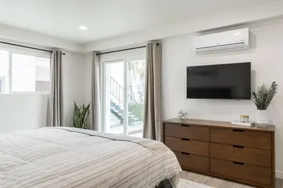 a bedroom with a bed and a flat screen tv at The Rosemont III - La Jolla Luxury in San Diego