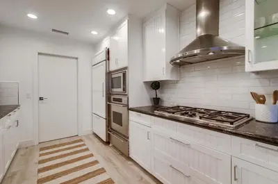 a kitchen with white cabinets and a stove top oven at The California - On Top of San Diego in a Hot Tub in San Diego