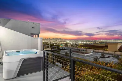 a hot tub on a balcony with a view of a city at The California III in San Diego