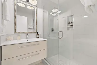 a white bathroom with a shower and a sink at The California III in San Diego