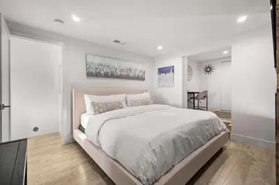 a white bedroom with a large bed and a table at The California III in San Diego