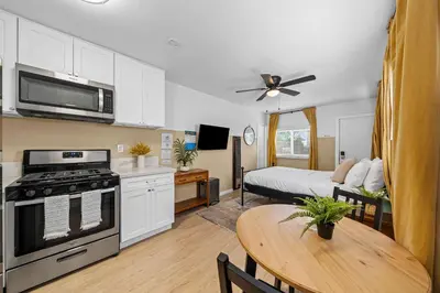 a kitchen and living room with a table and a bed at Live like a local - Studio with huge backyard in San Diego