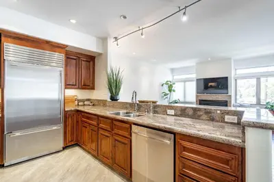 a kitchen with wooden cabinets and a stainless steel refrigerator at Your Home in San Diego - Two-Car Garage in San Diego