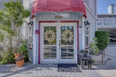 a front door of a building with a red awning at Pelican Cove Inn in Carlsbad