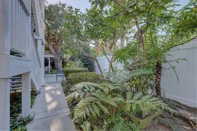 a garden with plants and trees next to a house at Pelican Cove Inn in Carlsbad