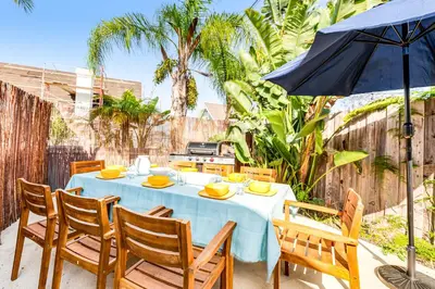 a table with chairs and an umbrella on a patio at Canyon Cove Oceanside in Oceanside