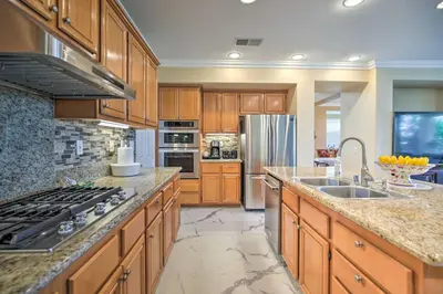 a kitchen with wooden cabinets and a stainless steel refrigerator at Luxury San Diego Home with Pool, Spa and Views! in San Diego