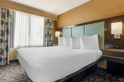 a large bed with white pillows in a hotel room at Best Western Plus Oceanside Palms in Oceanside