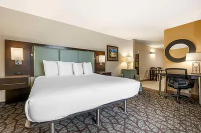 a hotel room with a large bed and a desk at Best Western Plus Oceanside Palms in Oceanside