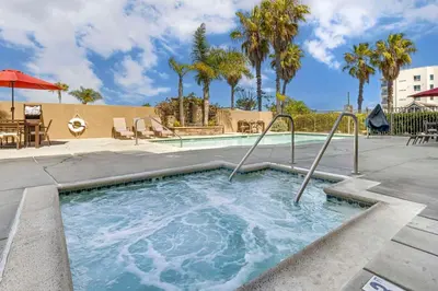 a swimming pool with a hot tub and palm trees at Best Western Plus Oceanside Palms in Oceanside