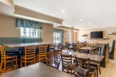 a restaurant with tables and chairs and a bar at Best Western Plus Oceanside Palms in Oceanside