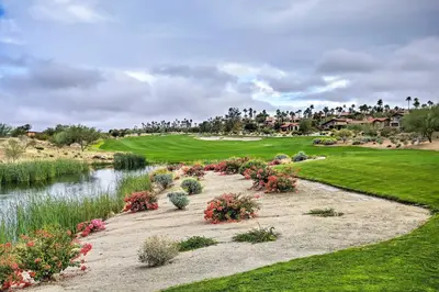 a view of a golf course with a pond and flowers at Roadrunner Roost at Rams Hill Golf Resort! in Borrego Springs