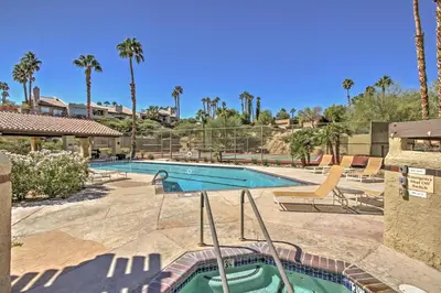 a swimming pool in a resort with palm trees at Roadrunner Roost at Rams Hill Golf Resort! in Borrego Springs
