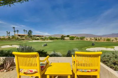 two yellow chairs and a table in front of a golf course at Roadrunner Roost at Rams Hill Golf Resort! in Borrego Springs
