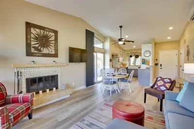 a living room with a fireplace and a dining room at Roadrunner Roost at Rams Hill Golf Resort! in Borrego Springs