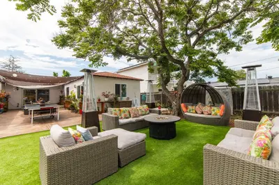 a backyard with wicker furniture and a tree at Casa Sur in Chula Vista