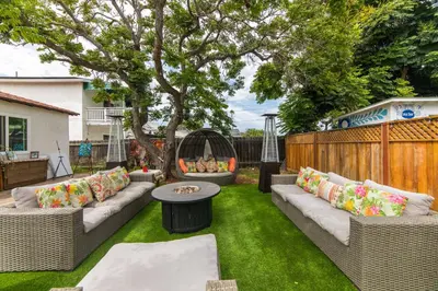 a backyard with wicker furniture and a tree at Casa Sur in Chula Vista