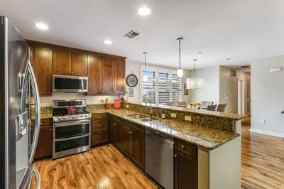 a kitchen with wooden cabinets and stainless steel appliances at Seacliff Retreat in Oceanside