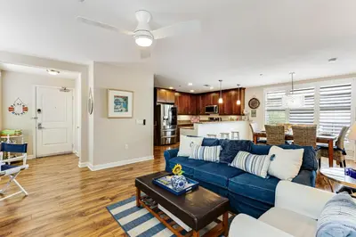 a living room with a blue couch and a kitchen at Seacliff Retreat in Oceanside
