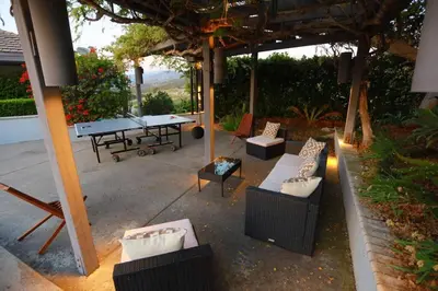 an outdoor patio with couches and a ping pong table at Luxury Modern Chateau near wineries & beaches in Fallbrook