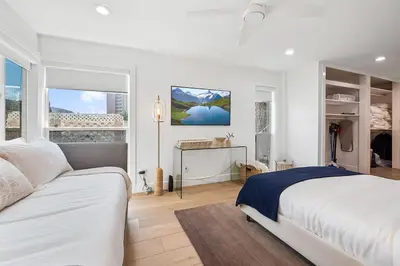 a white bedroom with a bed and two windows at Hideaway Zen in San Diego