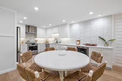 a white kitchen with a white table and chairs at Hideaway Zen in San Diego