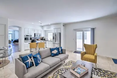 a living room with a couch and a kitchen at Oceanside Home with Rooftop Patio - Steps to Beach! in Oceanside
