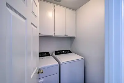 a small laundry room with a washer and dryer at Oceanside Home with Rooftop Patio - Steps to Beach! in Oceanside
