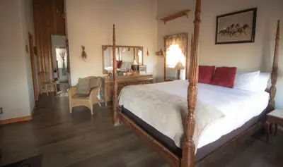 a bedroom with a bed and a desk with a mirror at Tucker Peak Lodge in Julian