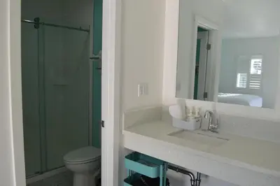 a bathroom with a toilet and a sink and a mirror at Calafia Inn San Clemente Newly renovated in San Clemente