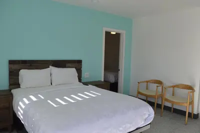 a bedroom with a large bed and two chairs at Calafia Inn San Clemente Newly renovated in San Clemente