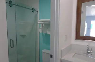 a bathroom with a glass shower and a sink at Calafia Inn San Clemente Newly renovated in San Clemente