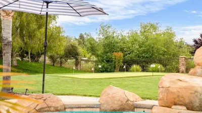 a pool with an umbrella next to a tennis court at Secluded Estate Exclusive Views of Wine Country Private Home Theater Twilight Vines by AvantStay in Sage