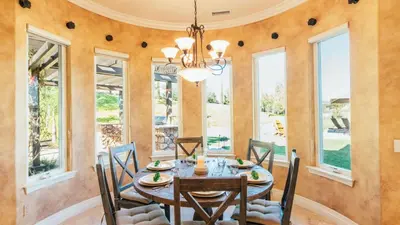 a dining room with a table and chairs and windows at Secluded Estate Exclusive Views of Wine Country Private Home Theater Twilight Vines by AvantStay in Sage