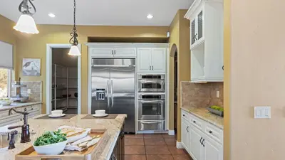 a kitchen with white cabinets and a stainless steel refrigerator at Wine Country Villa • Large Rooftop Terrace w Views Game Room Via del Sur in Temecula