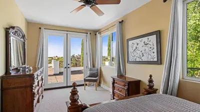 a bedroom with a bed and a chair and a window at Wine Country Villa • Large Rooftop Terrace w Views Game Room Via del Sur in Temecula